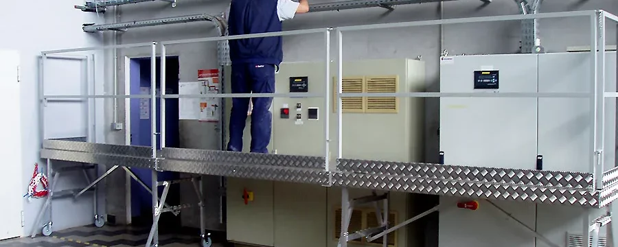 Electricien posant un chemin de câbles depuis la plateforme de travail en hauteur TSCS
